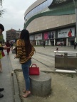 坐在路边石凳上等人的紫色尖头高跟美眉